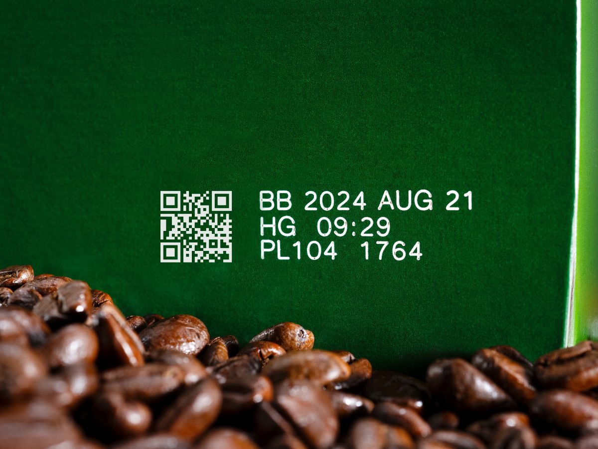 White laser-marked QR code and best-before date on a green coffee carton
